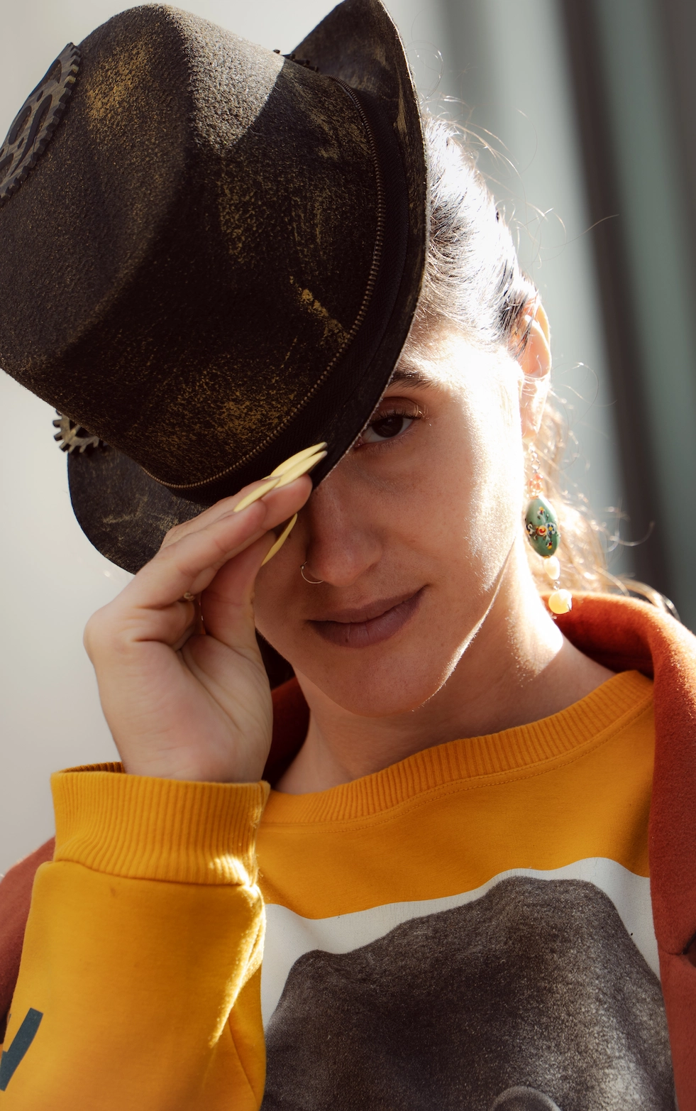 Natürliches Portrait einer lächelnden Frau mit Vintage-Hut und auffälligen Ohrringen — MarketRamp professionelle Fotografie