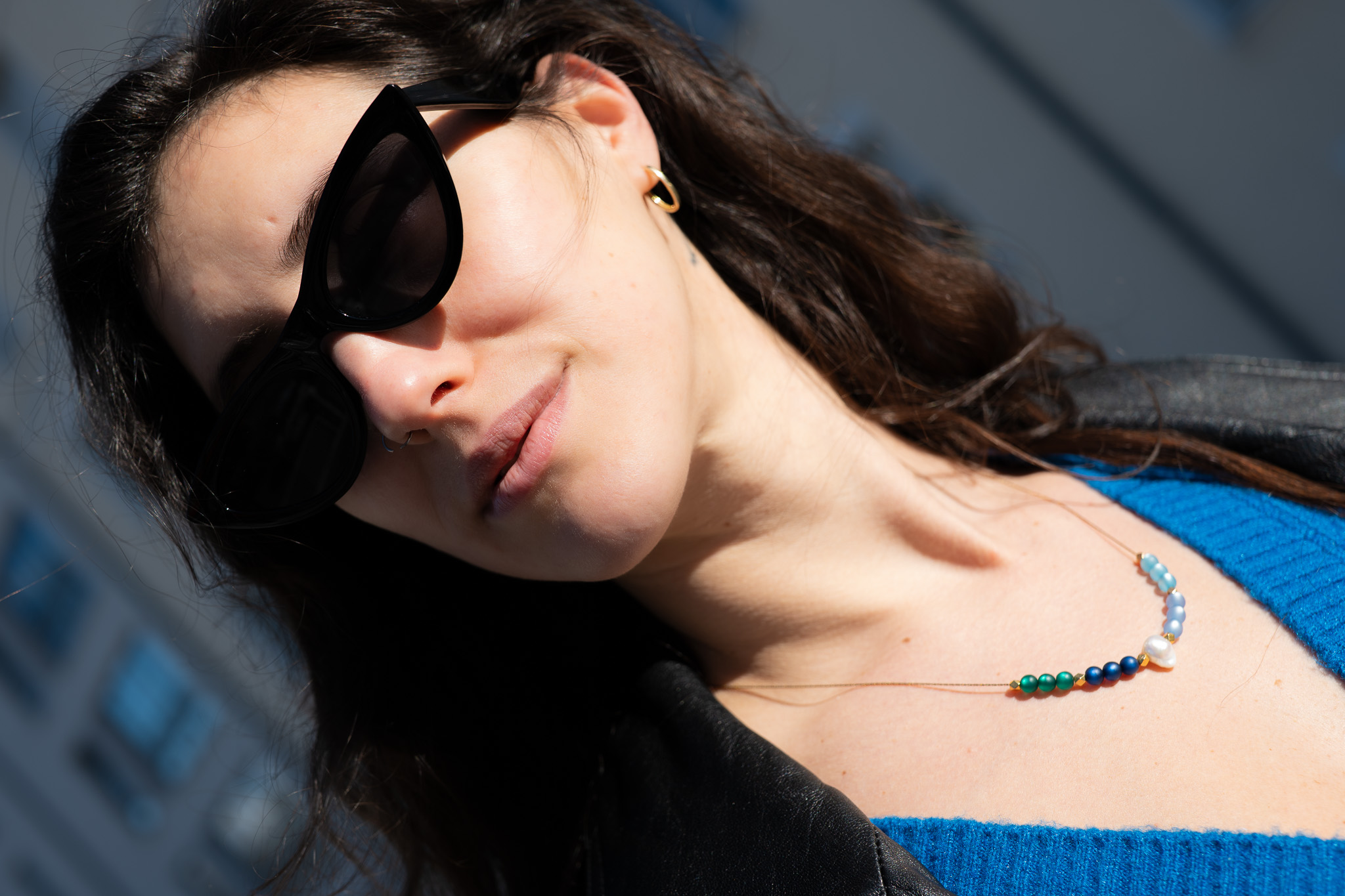 Lifestyle-Portrait einer Frau mit Sonnenbrille und Perlenkette im natürlichen Sonnenlicht — MarketRamp professionelle Fotografie