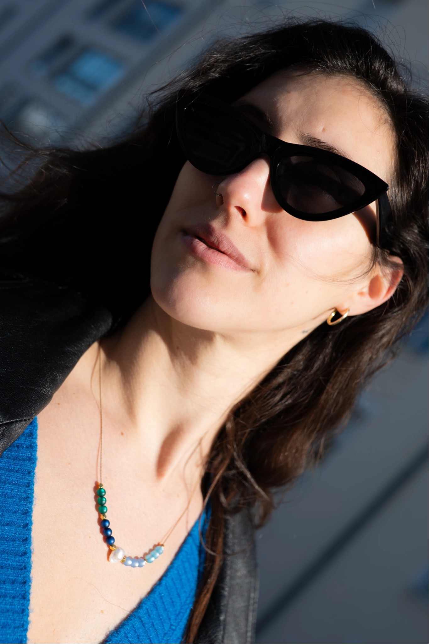 Lifestyle-Portrait einer Frau mit Sonnenbrille und Perlenkette im natürlichen Sonnenlicht — MarketRamp professionelle Fotografie